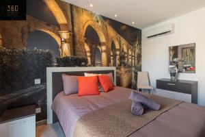 San ĠwannHigh-End central APT with comfy BED & Super WIFI by 360 Estates的一间卧室配有一张带橙色和紫色枕头的床
