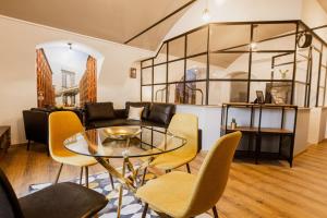a living room with a glass table and chairs at Dunakavics XIII Apartman in Szentendre