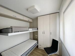 ein kleines Zimmer mit einem Bett und einem Stuhl in der Unterkunft Luxury Center Apartment in Benidorm