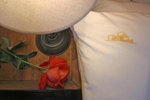 a person standing next to a red rose next to a bed at Hotel Rural Can Maries in Puerto de San Miguel