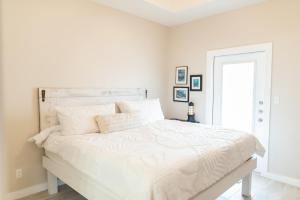 a white bedroom with a large bed with white sheets at Soulshine in Port Aransas