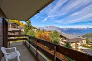 a balcony with a chair and a view of mountains at Appartement Valena 5 in La Tzoumaz