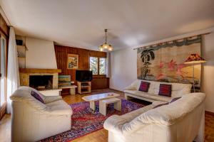 a living room with two white couches and a fireplace at Appartement Valena 5 in La Tzoumaz