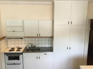 Una cocina blanca con gabinetes blancos y un fregadero. en Nu renoverad och uppgraderad bostad, mycket förbättrad, en Hedsjö
