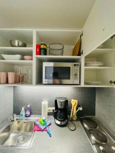 a kitchen counter with a sink and a microwave at Sunrise Studio für 2-3 Personen in Munich