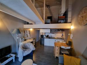 Il comprend un salon et une cuisine avec une mezzanine. dans l'établissement Studio AU CENTRE de Chimay, arrivee autonome, à Chimay