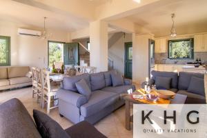 a living room with a blue couch and a table at Villa Elaionas 1 Experiencing nature's tranquility! in Svoronata