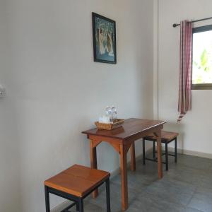 un tavolo e due sgabelli in una stanza di Yoga Homestay Seka a Seka
