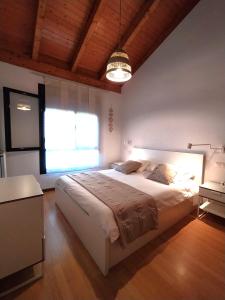 a bedroom with a large bed and a large window at Adosado de María - Para 4 pax en Posada de Llanes in Llanes