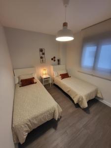 - une chambre avec 2 lits et une lampe dans l'établissement Alazán Jerez IV-Parking gratis-Wifi-Netflix, à Jerez de la Frontera