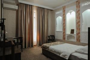 a hotel room with a bed and a desk at Omar Khayyam Hotel in Bukhara