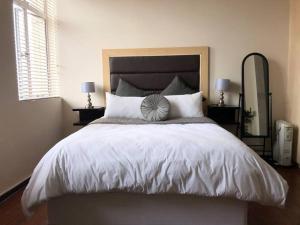 a bedroom with a large bed with a large headboard at Lovely 2 Storey apartment with pool, gym and bar in Johannesburg
