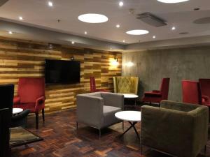 a waiting room with chairs and a flat screen tv at Seventh Heaven in Johannesburg