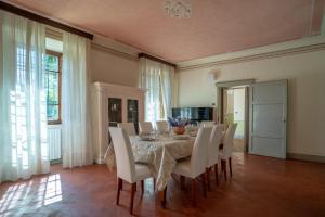 a dining room with a table and white chairs at Villa Lama by Mmega in Lama
