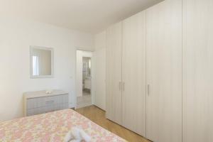 a white bedroom with a bed and white cabinets at Da Nonna Antonia in Martellago