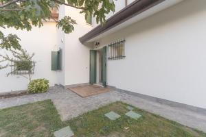 un edificio blanco con una puerta verde. en Da Nonna Antonia en Martellago