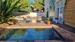a backyard with a swimming pool with chairs and a table at Zona5 Apartamentos Turísticos in El Vendrell