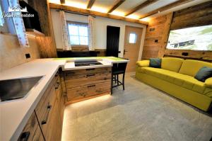 a kitchen with a yellow couch in a room at Mountain Chalet Scoiattolo in Livigno