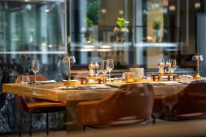 una larga mesa de madera con copas de vino. en Hotel Kö59 Düsseldorf - Member of Hommage Luxury Hotels Collection en Düsseldorf