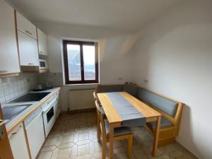 a small kitchen with a wooden table and a window at Apartment 2 Feistriz in Rosental 9181 in Feistritz im Rosental
