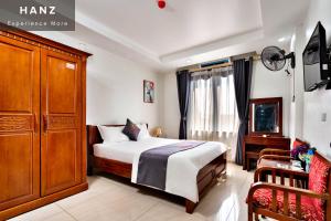 a bedroom with a bed and a cabinet and a chair at HANZ Duc Hieu 1 Hotel in Hanoi