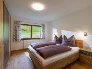 sypialnia z dużym łóżkiem i oknem w obiekcie Ferienhaus Widmann w mieście Kirchberg in Tirol