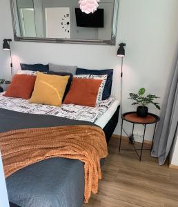 1 dormitorio con cama con almohadas y espejo en StarHomes Double lux 7, en Oulu