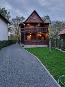 une grande maison en bois avec une allée en gravier dans l'établissement Oak Holiday House Nature, à Krapje