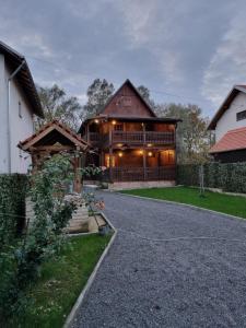 Une grande maison en bois avec une allée se trouve en face de l'établissement. dans l'établissement Oak Holiday House Nature, à Krapje