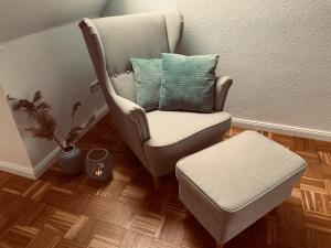 einen Stuhl mit einem Kissen und einem Stuhl in einem Zimmer in der Unterkunft mitten im dorf in Worpswede