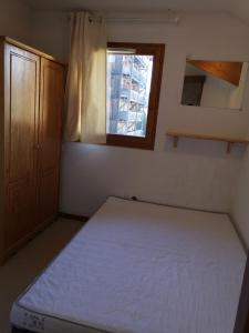 a small bedroom with a bed and a window at Appartement cosy dans chalet vue Montagne in Le Dévoluy