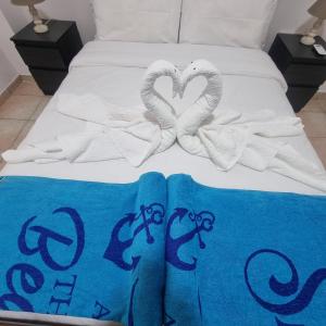 a bed with two towels and two swan towels at Potamos Private Suites in Paphos City