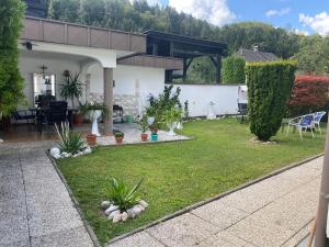 a backyard with a lawn with plants and a house at Apartment 2 Feistriz in Rosental 9181 in Feistritz im Rosental