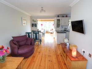 ein Wohnzimmer mit einem lila Stuhl und einem Tisch in der Unterkunft Teach Teolai in Carraroe