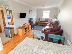 ein Wohnzimmer mit einem Sofa und einem Tisch in der Unterkunft Teach Teolai in Carraroe