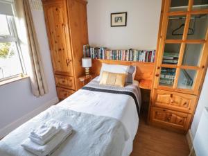 a bedroom with a bed and a book shelf at Teach Teolai in Carraroe