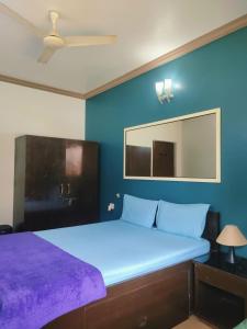 a bedroom with a large bed and a mirror at Goa Homeland 3 double bed Calangute in Calangute