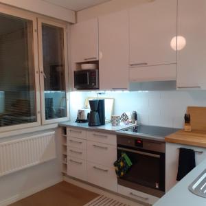 エスポーにある2 room apartment in Tapiolaのキッチン(白いキャビネット、コンロ付)