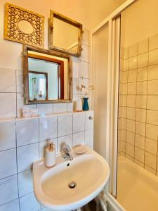 ein Bad mit einem Waschbecken, einem Spiegel und einer Dusche in der Unterkunft Appartement Buntspecht in Erfurt