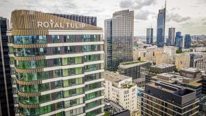 华沙Royal Tulip Warsaw Centre的一座高楼，楼顶挂着皇家导师的标志