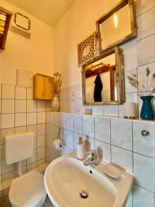 a bathroom with a sink and a toilet and a mirror at Appartement Buntspecht in Erfurt