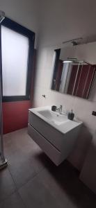 un bagno con un lavandino bianco e uno specchio di B&B Juniperus a SantʼAnna Arresi