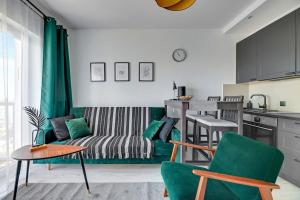a living room with a couch and a table at Albatross Tower - apartament w centrum Przymorza by Grand Apartments in Gdańsk