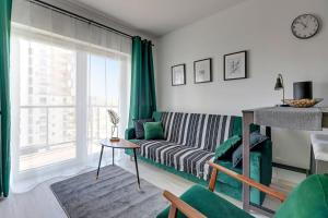 a living room with a couch and a large window at Albatross Tower - apartament w centrum Przymorza by Grand Apartments in Gdańsk