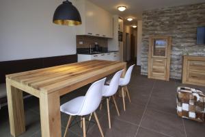 a kitchen with a wooden table and white chairs at Ski & Golf Suites Zell am See by Alpin Rentals in Zell am See