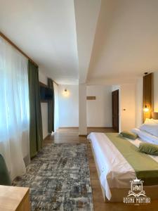 a hotel room with two beds and a rug at Regina Munților Spa&Confort in Moieciu de Sus
