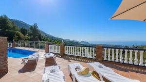 balcón con tumbonas blancas y piscina en Villa el Pedregal Frigiliana by Ruralidays, en Frigiliana