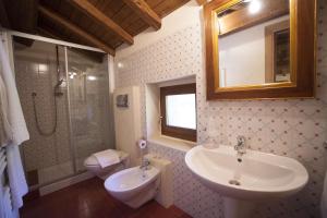 a bathroom with a sink and a toilet and a mirror at Albergo Diffuso La Piana dei Mulini in Colledanchise +99 photos