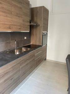uma cozinha com armários de madeira e um lavatório de aço inoxidável em Blue & Grey downtown Foggia em Foggia