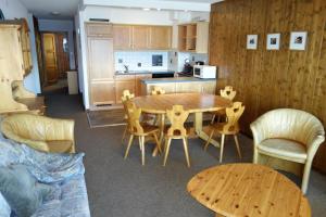 eine Küche und ein Esszimmer mit einem Holztisch und Stühlen in der Unterkunft Magrappé MOUNTAIN & CENTER apartments in Veysonnaz